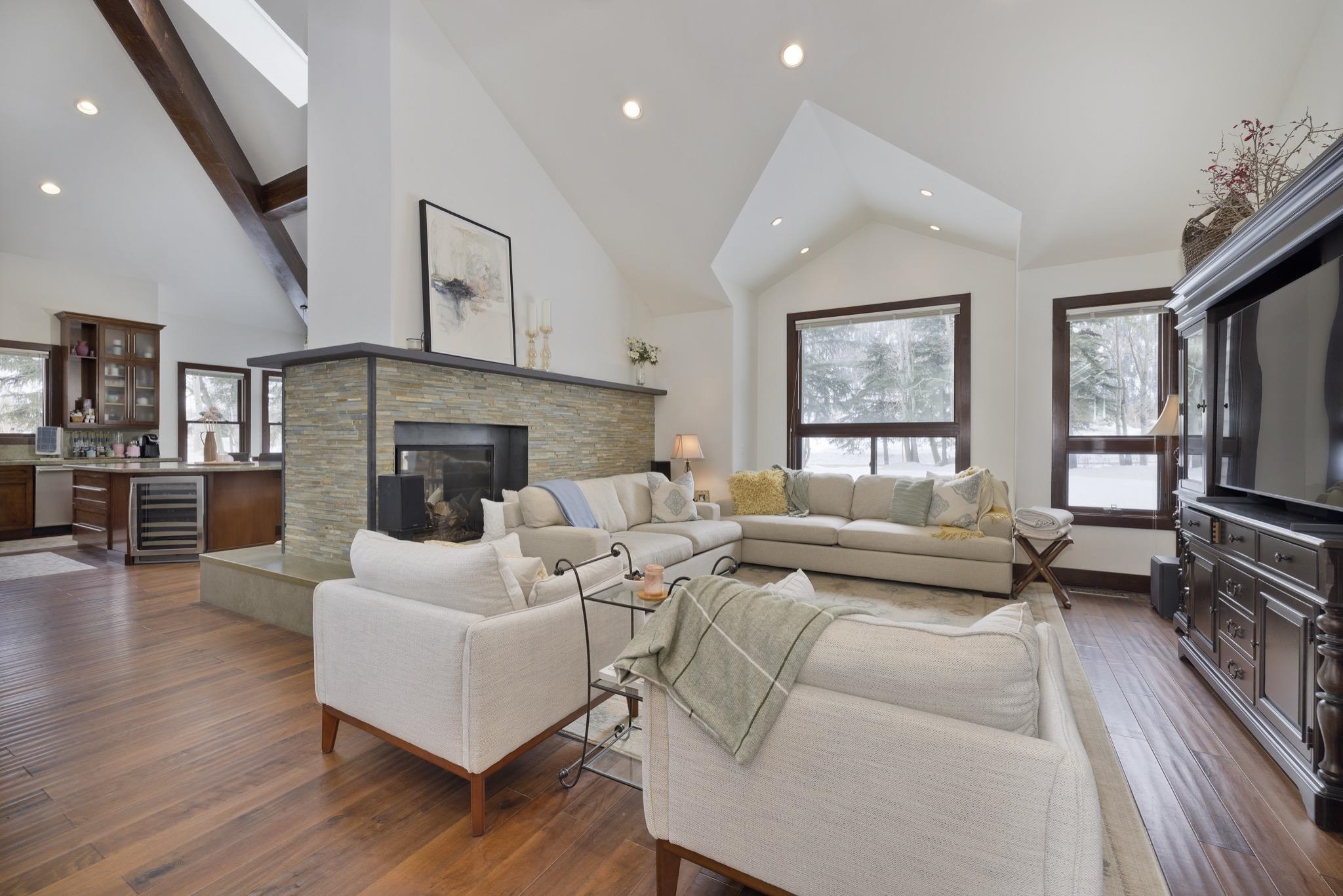 310 Ranch Road Mammoth Lakes, CA 93546 - Photo 5 of 40 Living room featuring wood-type flooring, beverage cooler, a stone fireplace, high vaulted ceiling, and recessed lighting