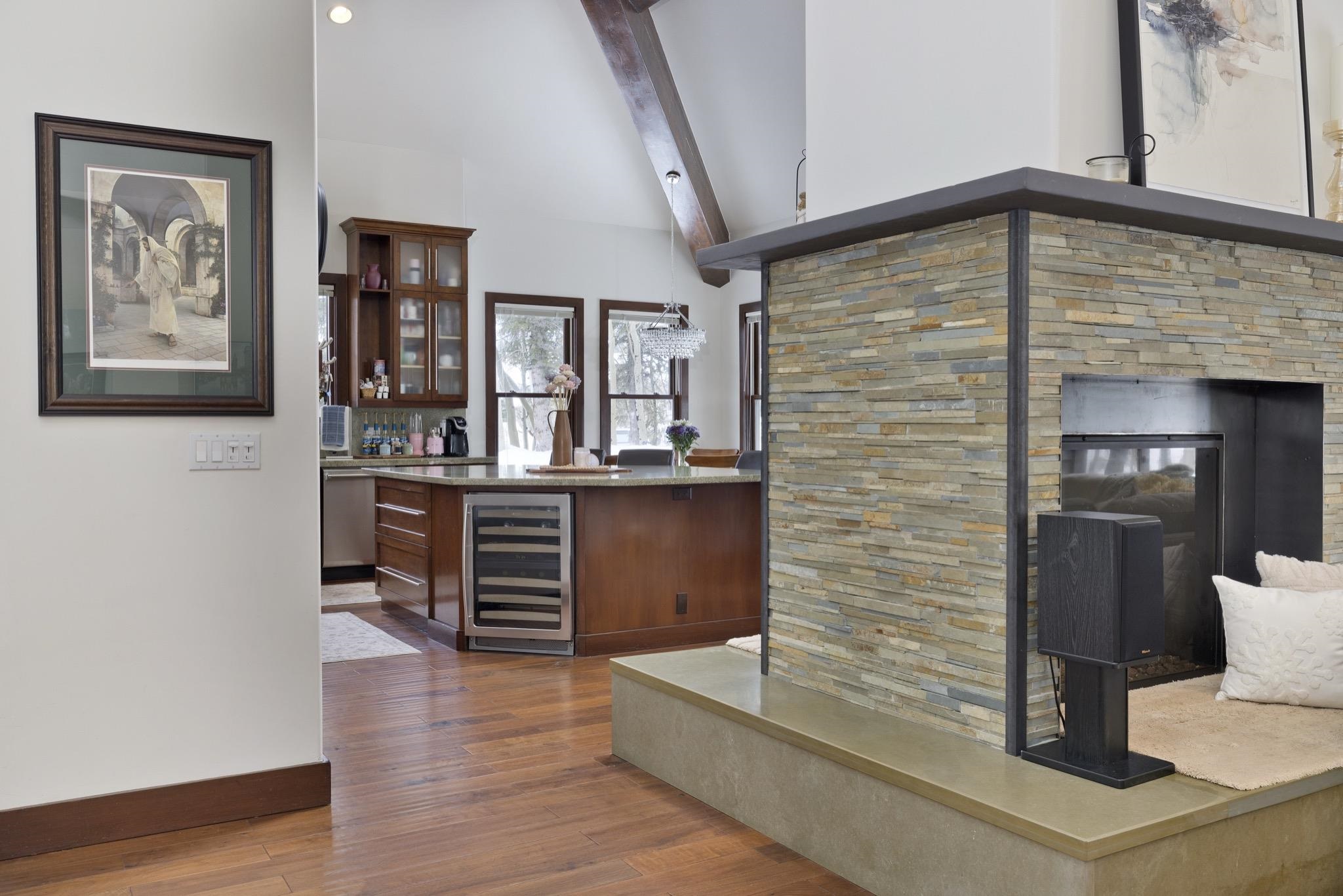 310 Ranch Road Mammoth Lakes, CA 93546 - Photo 6 of 40 Indoor dry bar with glass insert cabinets, wine cooler, dark wood finished floors, a fireplace, and light stone countertops