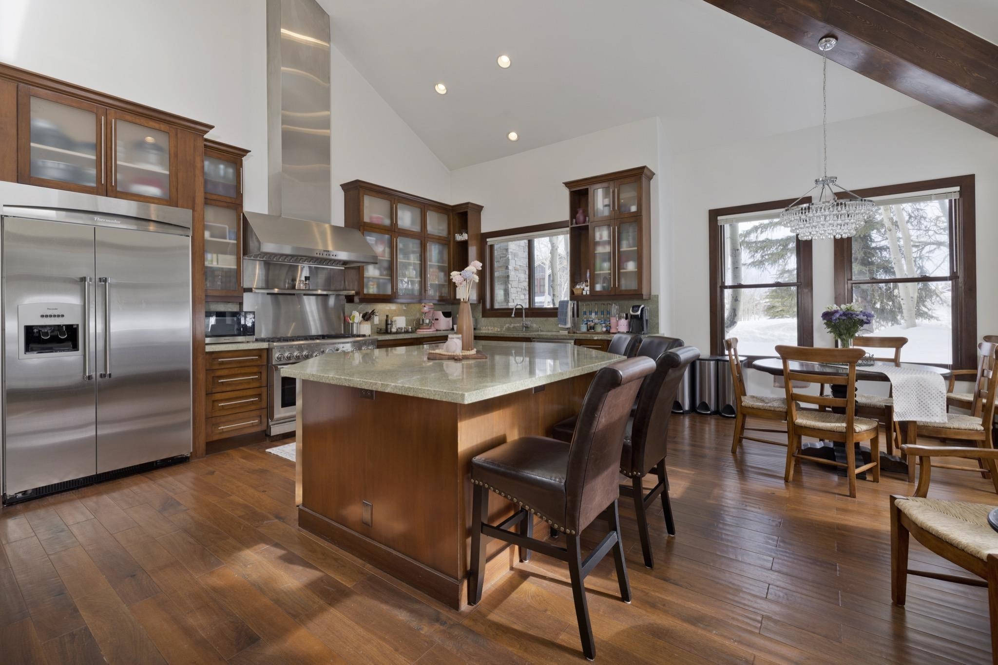 310 Ranch Road Mammoth Lakes, CA 93546 - Photo 9 of 40 Kitchen with high end appliances, high vaulted ceiling, pendant lighting, wall chimney range hood, and dark wood-type flooring