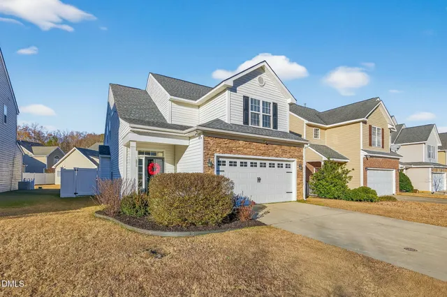 a view of a white house next to a yard with road