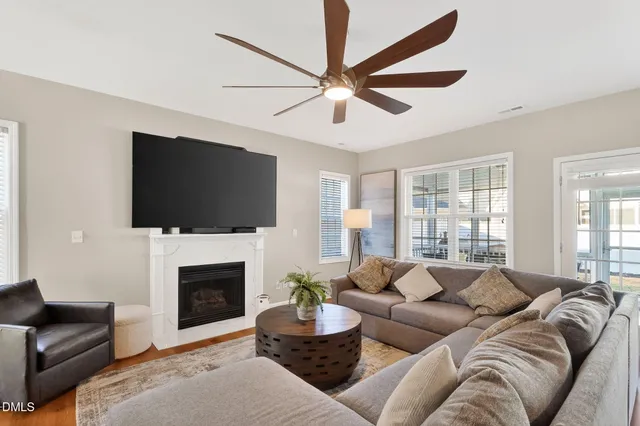 a living room with furniture a flat screen tv and a fireplace