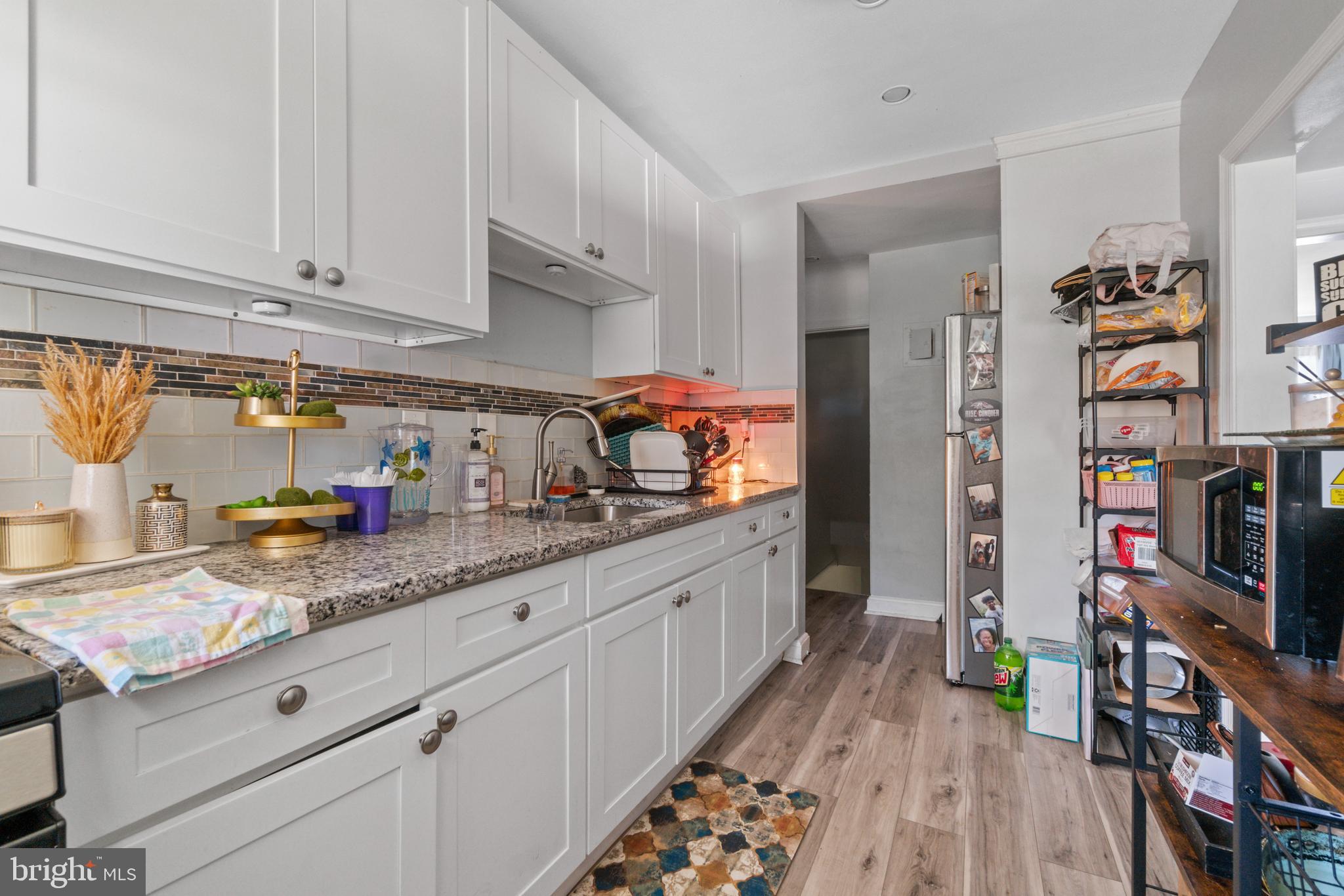 1322 East Cold Spring Lane Baltimore, MD 21239 - Photo 8 of 21 a kitchen with granite countertop lots of clutter and stainless steel appliances