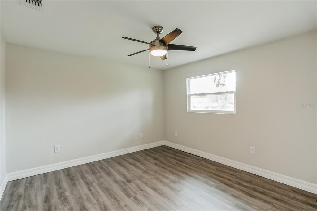 224 Singleton Avenue Arcadia, FL 34266 - Photo 12 of 24 an empty room with wooden floor ceiling fan and windows