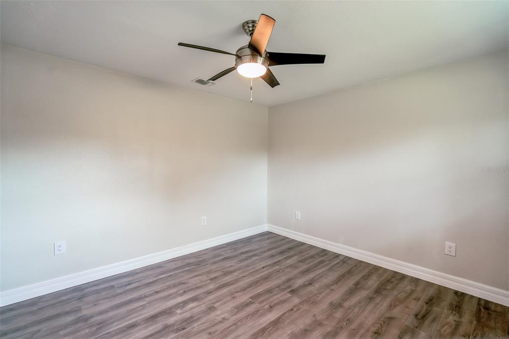 224 Singleton Avenue Arcadia, FL 34266 - Photo 17 of 24 a view of a room with wooden floor ceiling fan and window