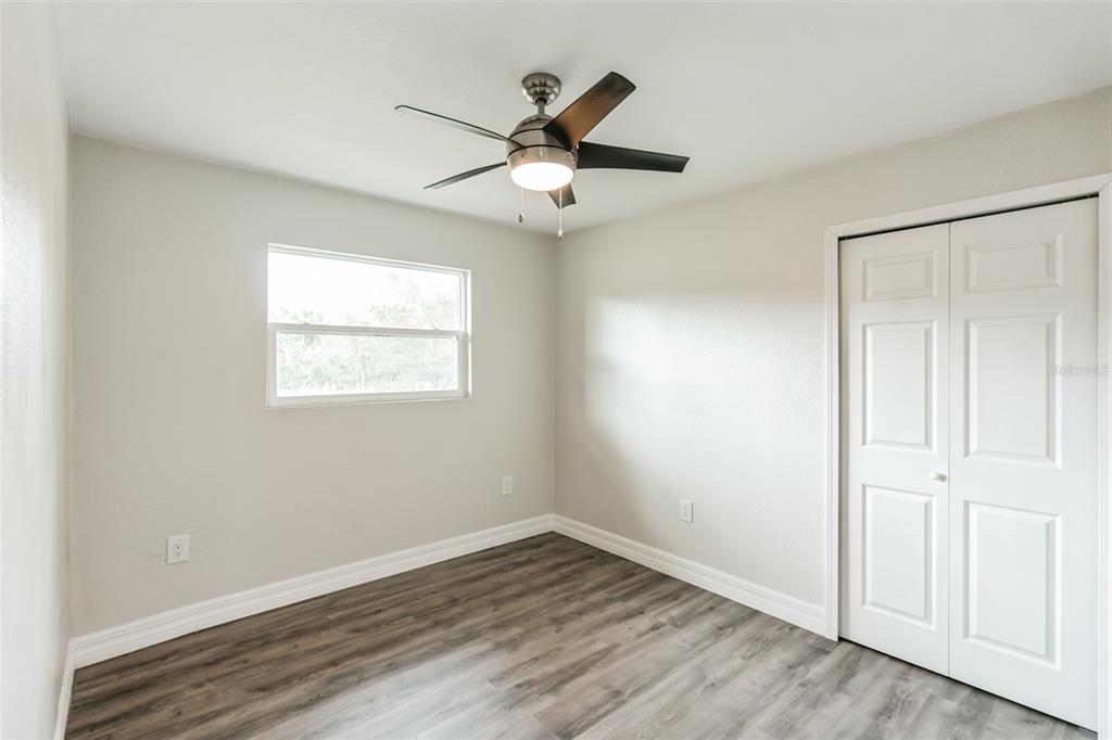 224 Singleton Avenue Arcadia, FL 34266 - Photo 18 of 24 an empty room with wooden floor ceiling fan and windows