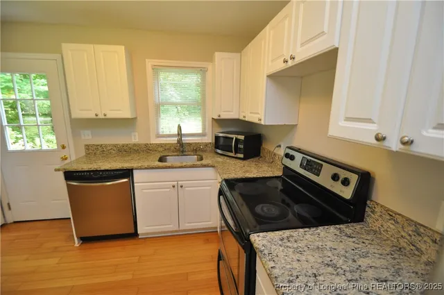 a kitchen with stainless steel appliances granite countertop a stove a sink and a microwave