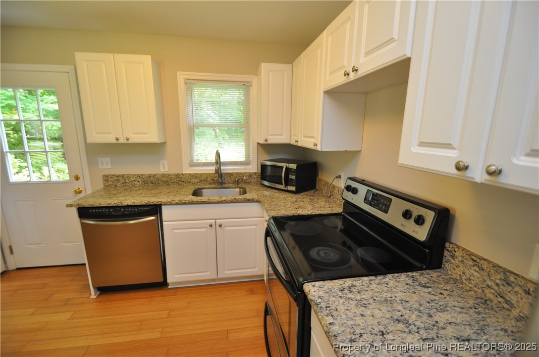 326 Webster Street Cary, NC 27511 - Photo 10 of 20 a kitchen with stainless steel appliances granite countertop a stove a sink and a microwave