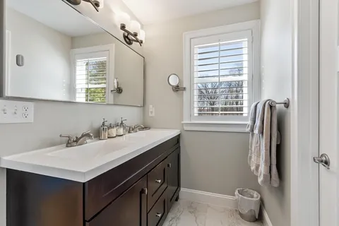 a bathroom with a sink vanity and a tub