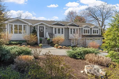 a front view of a house with a yard and potted plants