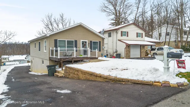 a view of a white house with a yard covered in snow