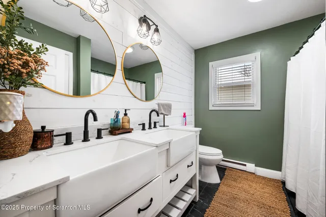 a bathroom with a double vanity sink mirror and toilet