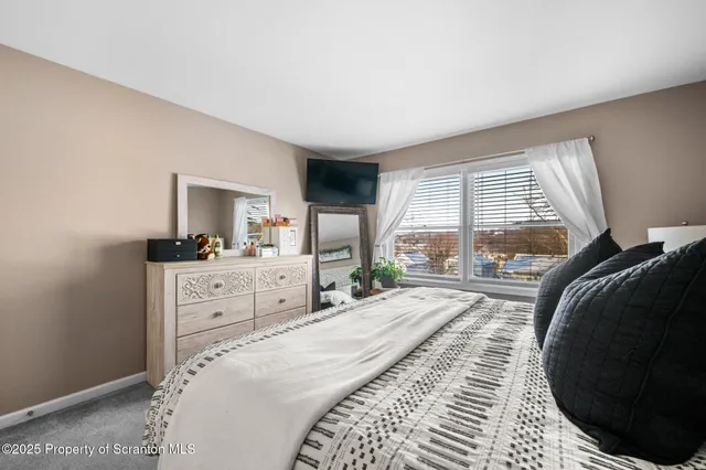 a bedroom with a bed and a large window