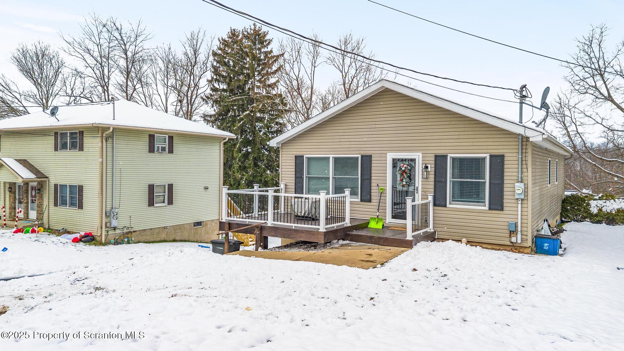 176 Poplar Street Archbald, PA 18403 - Photo 32 of 34 a backyard of a house with table and chairs under an umbrella