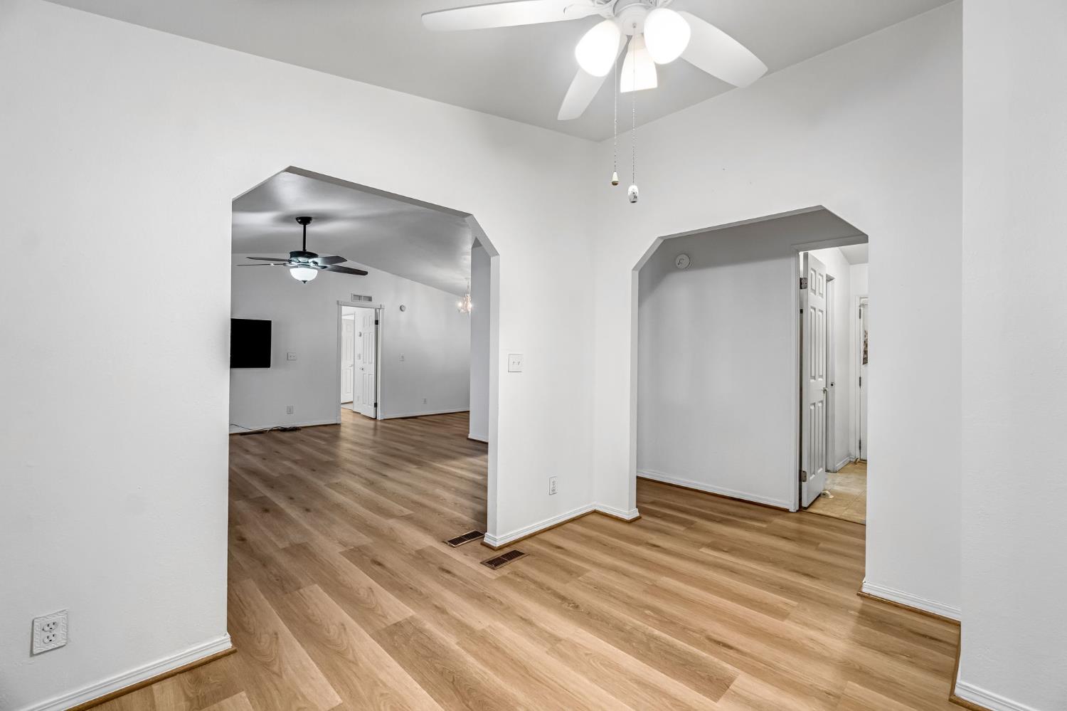 1218 East Cleveland Avenue, Unit 142 Madera, CA 93638 - Photo 16 of 32 an empty room with wooden floor and staircase