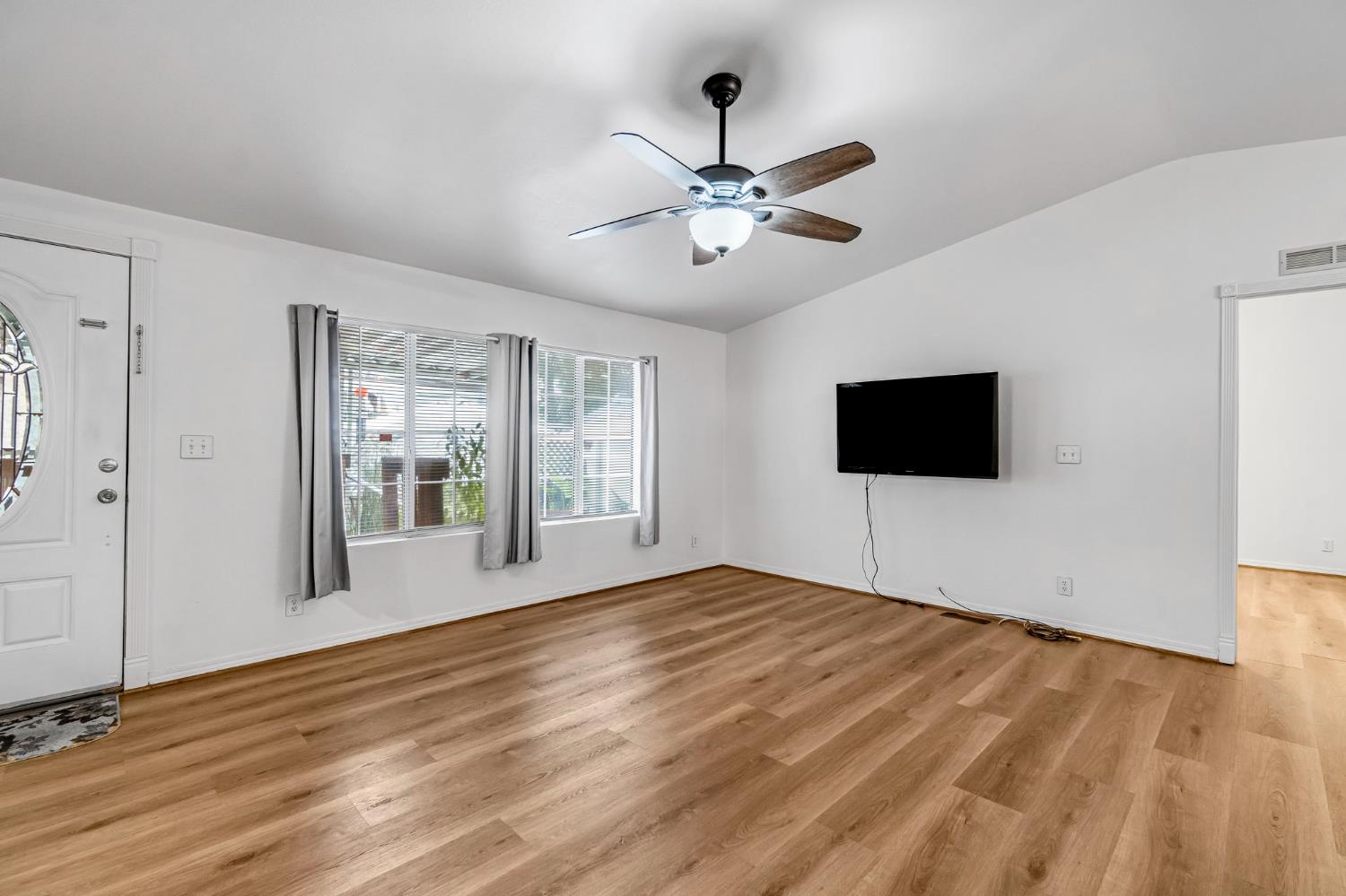 1218 East Cleveland Avenue, Unit 142 Madera, CA 93638 - Photo 6 of 32 a view of an empty room with a window and wooden floor