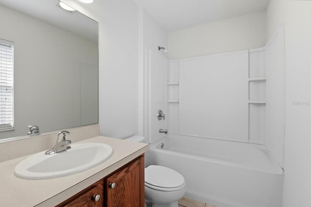 4059 Southwest 51st Road Ocala, FL 34474 - Photo 25 of 42 a bathroom with a sink a toilet and shower