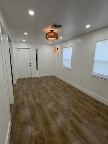 an empty room with ceiling fan and window