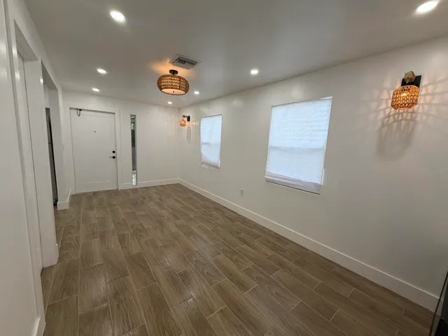 a kitchen with granite countertop a sink a stove top oven a counter space and cabinets