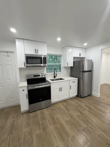 an empty room with wooden floor and window