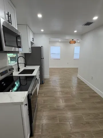 a view of an empty room with wooden floor