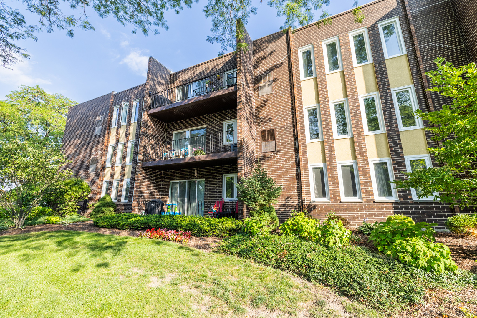 1525 Sander Court, Unit 103 Wheeling, IL 60090 - Photo 3 of 28 a view of a building with brick walls and plants