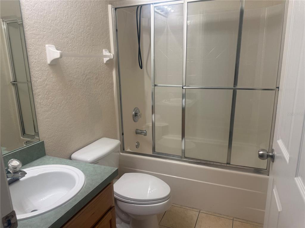 927 Reserve Place Davenport, FL 33896 - Photo 11 of 18 a bathroom with a granite countertop sink toilet and shower