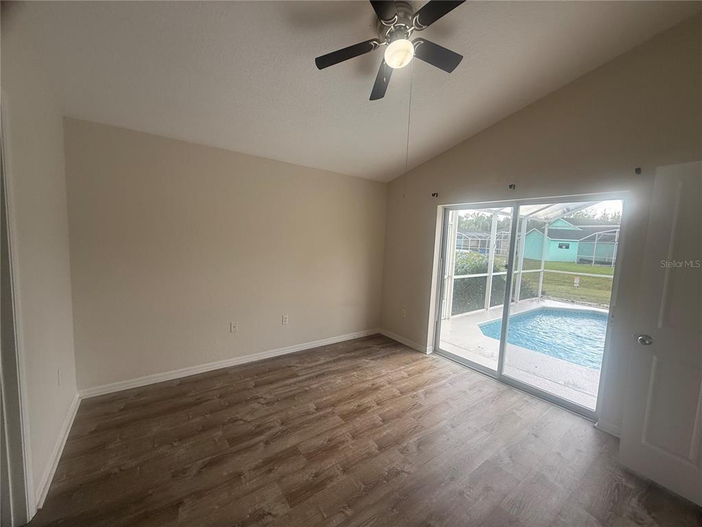 927 Reserve Place Davenport, FL 33896 - Photo 6 of 18 an empty room with chandelier fan and windows