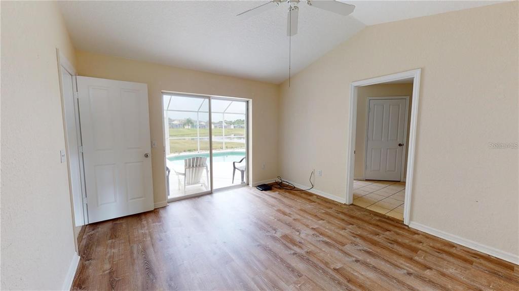 927 Reserve Place Davenport, FL 33896 - Photo 7 of 18 an empty room with wooden floor and windows