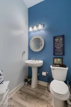 a bathroom with a toilet a sink and a mirror