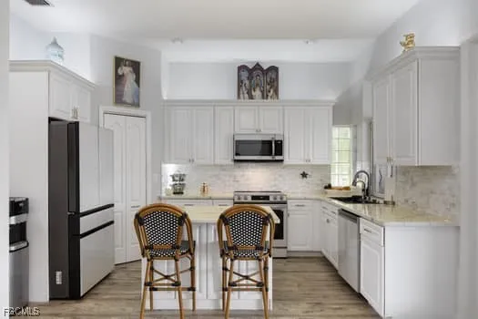 a kitchen with stainless steel appliances a refrigerator a sink a stove a table and chairs
