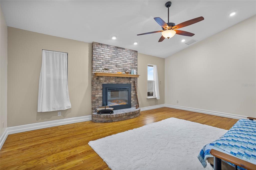 14612 Bray Road Orlando, FL 32832 - Photo 20 of 33 a view of a livingroom with a fireplace a ceiling fan and wooden floor