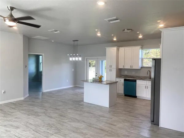 a large kitchen with kitchen island a sink stainless steel appliances and cabinets