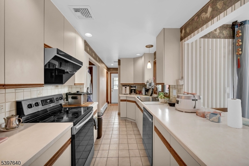 699 East Shore Road West Milford, NJ 07421 - Photo 19 of 50 a kitchen with a sink stove top oven and cabinets