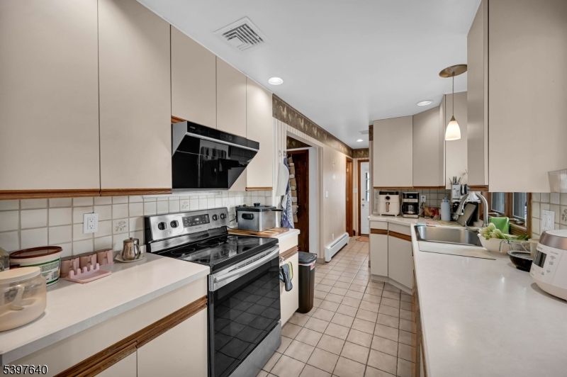 699 East Shore Road West Milford, NJ 07421 - Photo 20 of 50 a kitchen with a sink a stove and cabinets