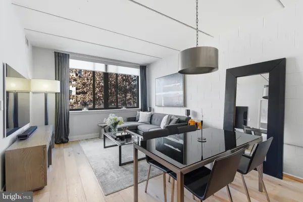 a living room with furniture a flat screen tv and a large window