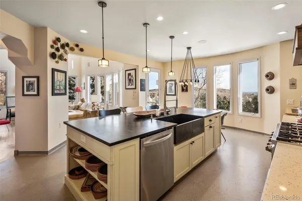 a kitchen with stainless steel appliances granite countertop a sink a stove and a wooden floor