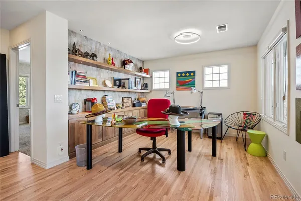 a workspace with furniture wooden floor and a book shelf