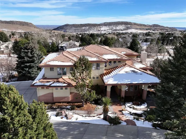 an aerial view of a house with yard and mountain view in back