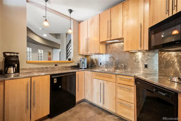 a kitchen with stainless steel appliances granite countertop a sink a stove and a microwave
