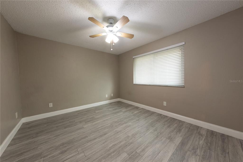 232 North Ridgewood Avenue, Unit 3A Edgewater, FL 32132 - Photo 12 of 19 a view of an empty room with wooden floor and a window