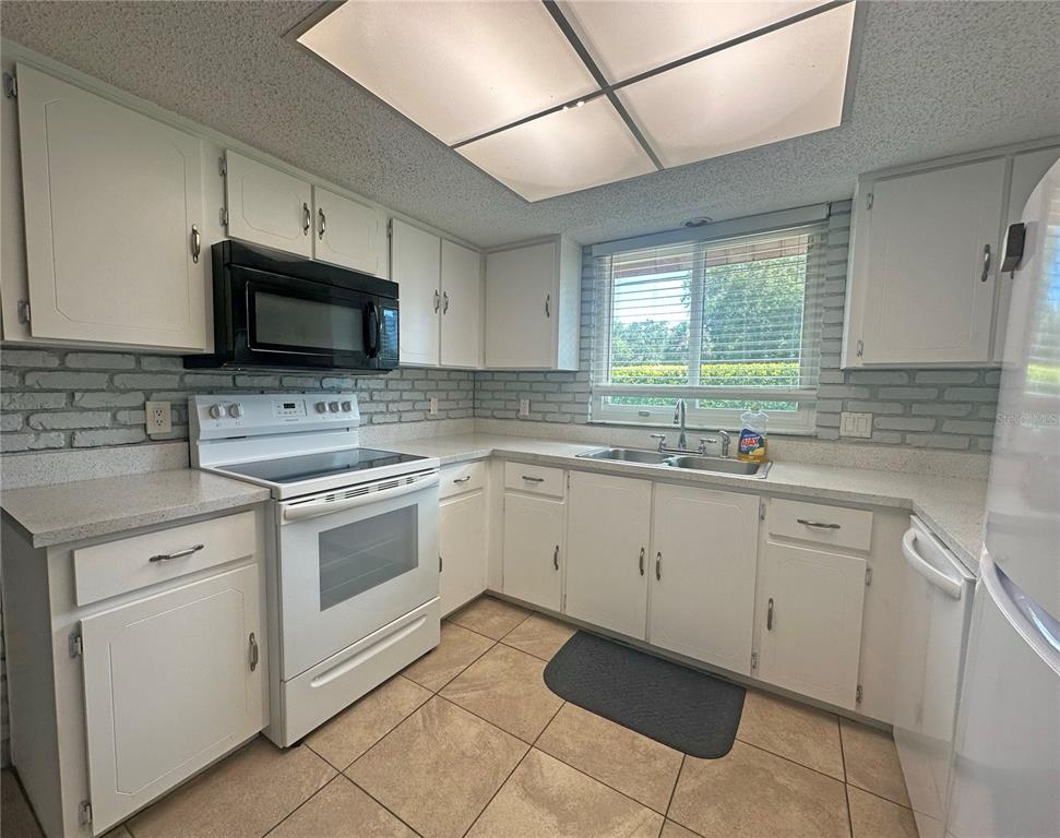 232 North Ridgewood Avenue, Unit 3A Edgewater, FL 32132 - Photo 6 of 19 a kitchen with cabinets stainless steel appliances and window
