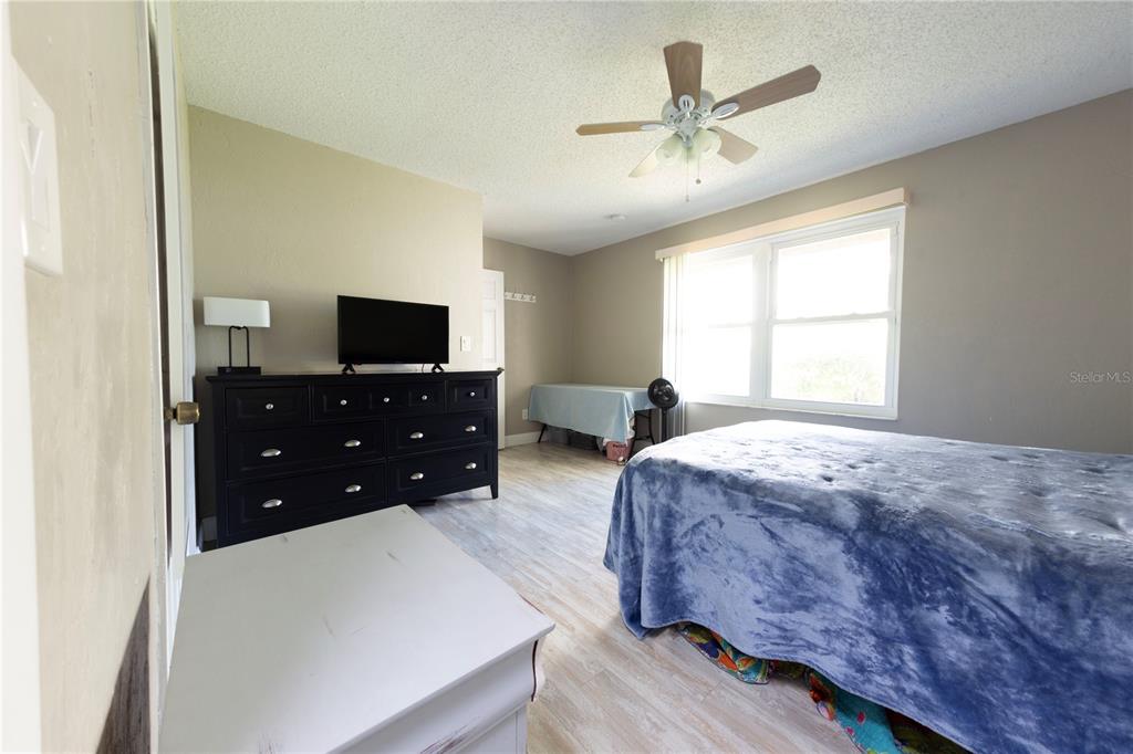 232 North Ridgewood Avenue, Unit 3A Edgewater, FL 32132 - Photo 9 of 19 a bedroom with a bed and a tv on dresser