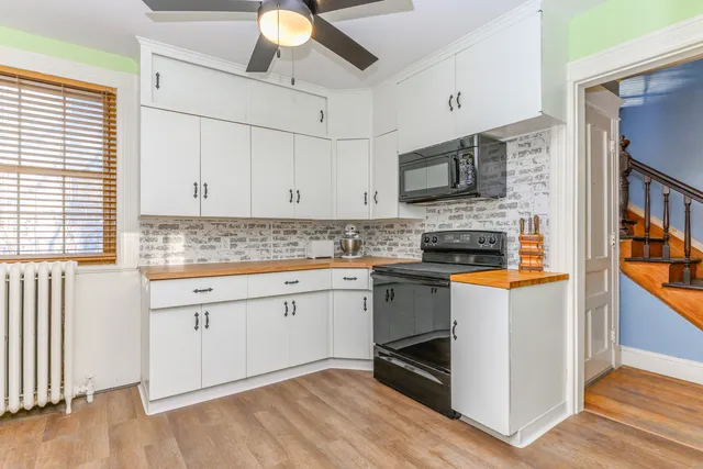 a kitchen with stainless steel appliances granite countertop a stove top oven a sink and a microwave