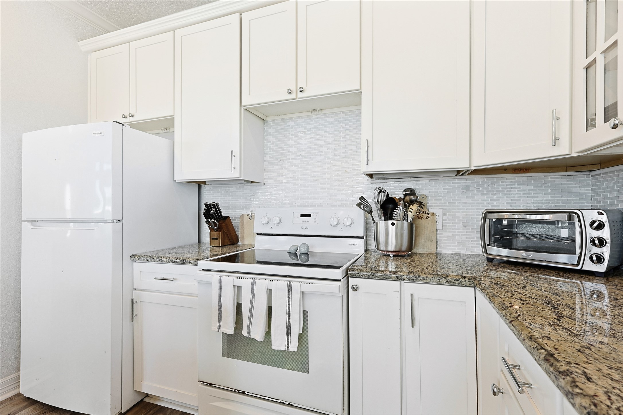4414 Palm Street Freeport, TX 77541 - Photo 13 of 35 a kitchen with granite countertop a refrigerator sink stove and microwave