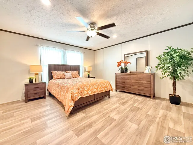 a bedroom with a large bed and a potted plant