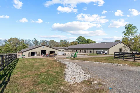 an aerial view of a residential houses with outdoor space and trees