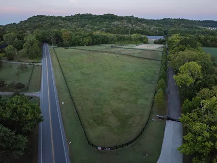 an aerial view of lake residential house with swimming pool and mountains
