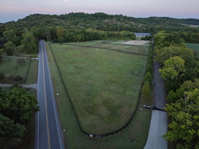 an aerial view of lake residential house with swimming pool and mountains
