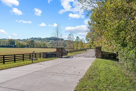 a view of a street with a bench and trees around