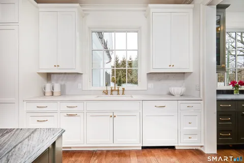 a kitchen with kitchen island granite countertop a stove a sink and a wooden floors